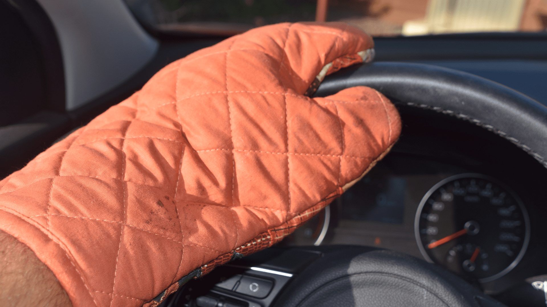 Oven mitt holding steering wheel